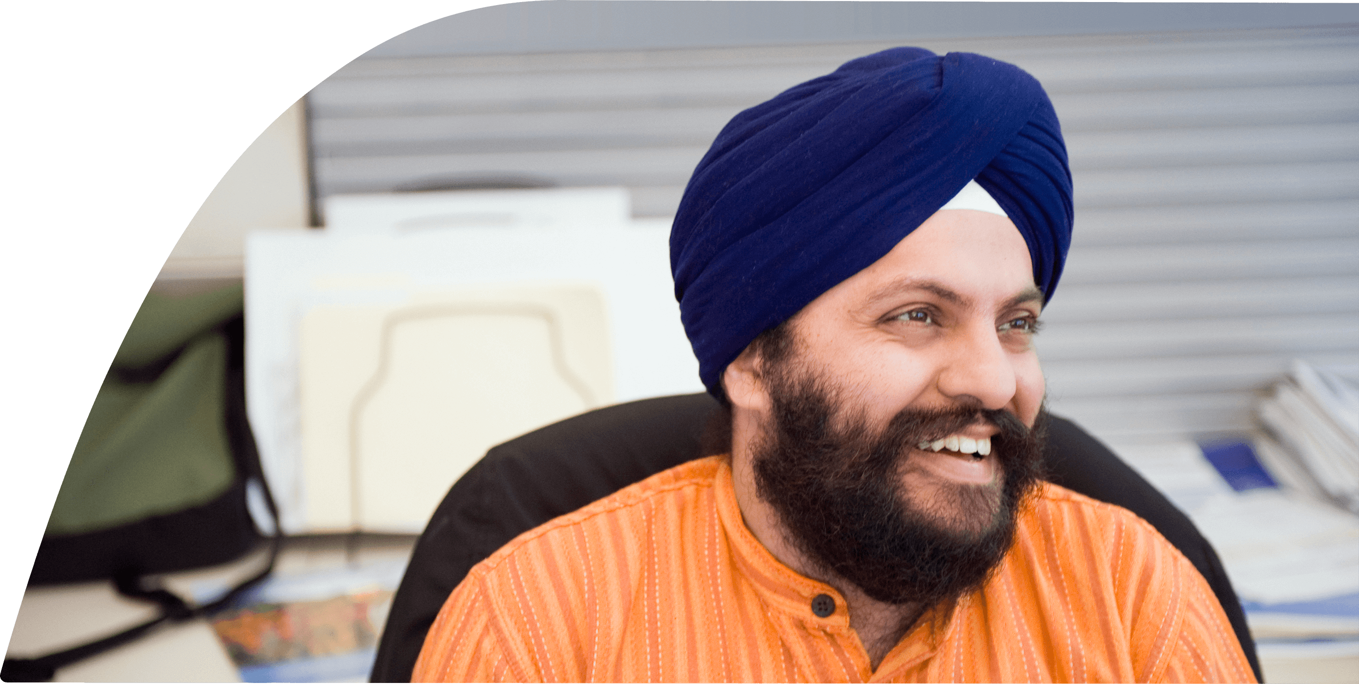 A man with a turban is smiling while sitting