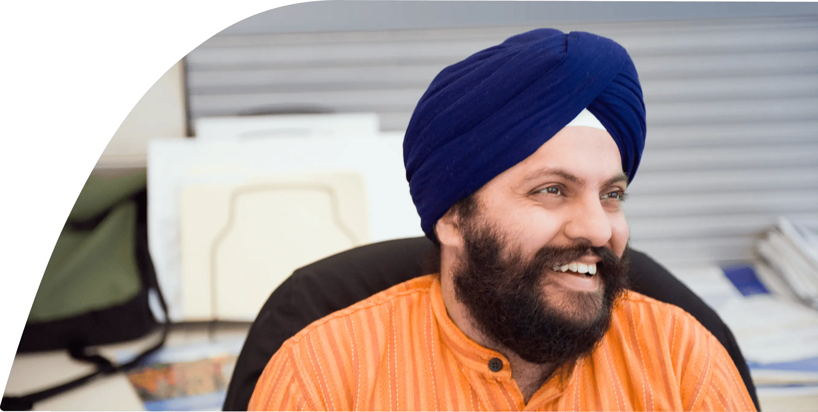 A man with a turban is smiling while sitting