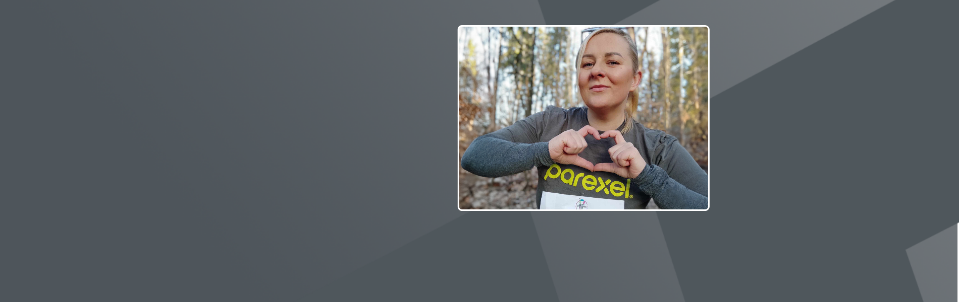 Laura at the Rare Disease Run 2024, wearing a Parexel t-shirt and shaping a heart with her hands.