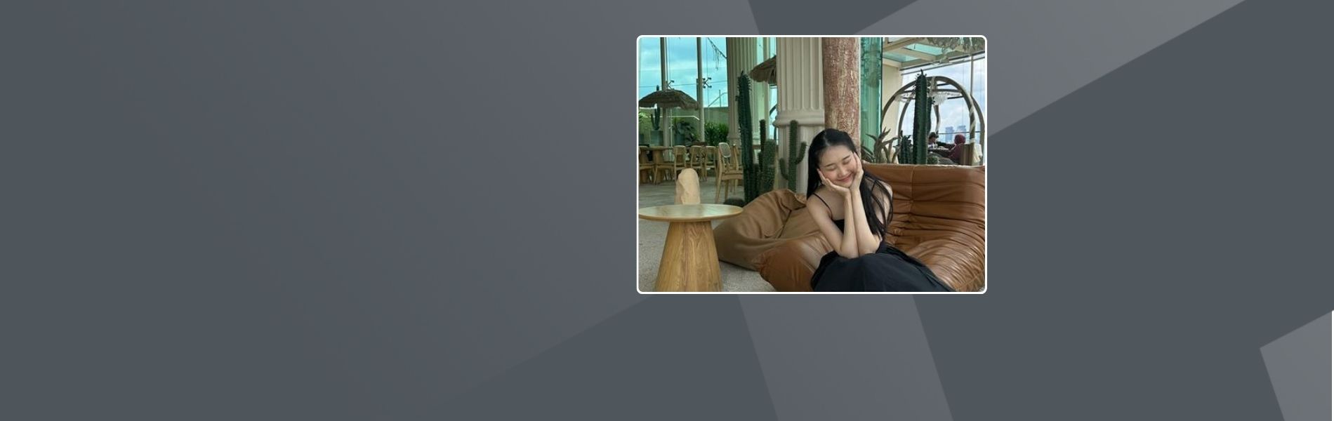 Wen Li, a woman in Malaysia, is sitting on a sofa in a coffee shop. She has long black hair and is wearing a black dress, with her hands resting on her cheeks