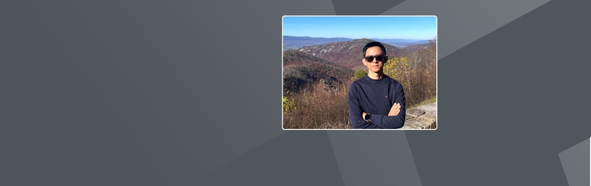 Larry, a Senior Director who wears sunglasses stand in front of the mountain views