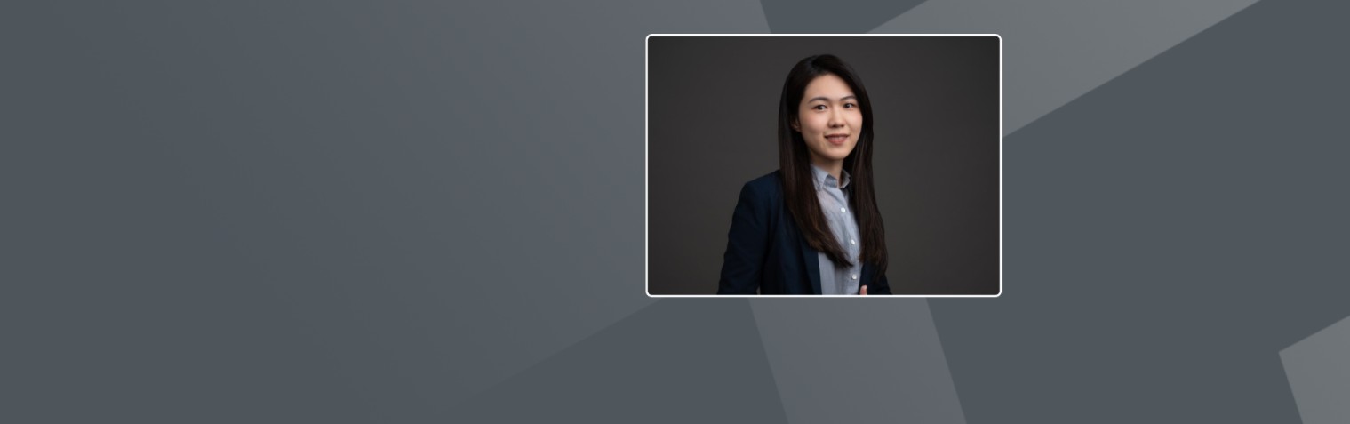 一位女士留着黑色长直发，穿着浅蓝色衬衫和黑色西装外套