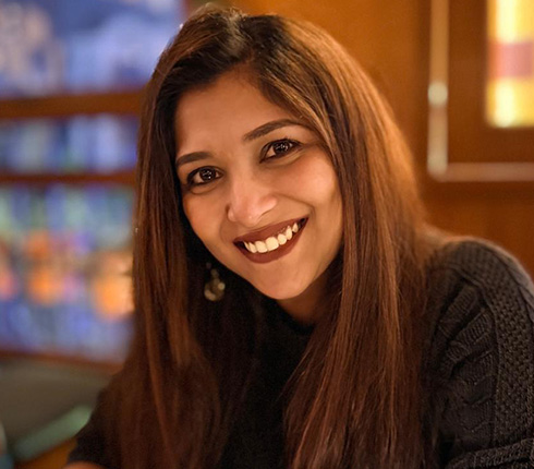 Amrita Maitra, Manager of Statistical Programmer in India, is smiling at the camera wearing dark black top. She has long dark brown hair and is in an indoor setting.
