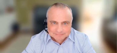 Boris Braylyan, SVP Data & Technology Management at Parexel, wearing headset in blue striped shirt during video interview.