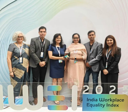A group of six people standing together at an event, posing for a photo. They appear to be at a professional gathering or conference.