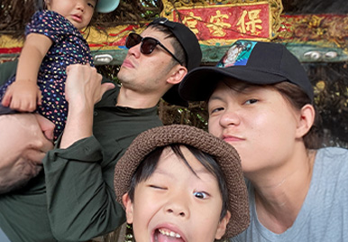 Joy Lin, Senior Director of Statistical Programming, is surrounded by her family; her husband, son and daughter. They are outside wearing outdoor attire.