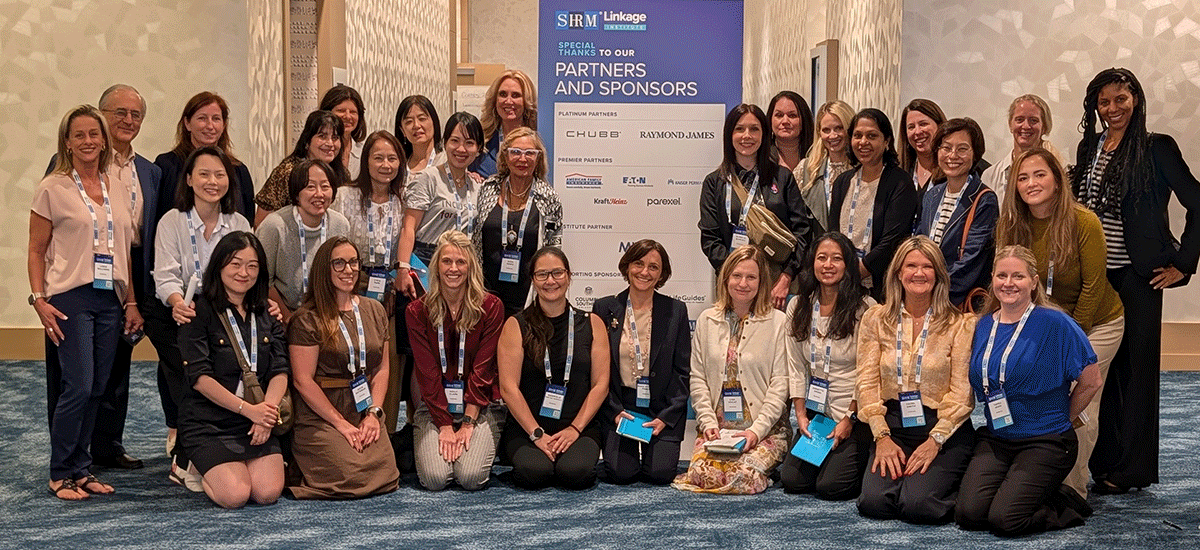 Mika among the 2025 Parexel Wayfinder in Leadership career development group at the Linkage Institute Conference. Approximately 35 women are gathered for two team photos.