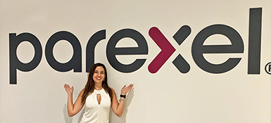 Picture of Carolina in front of a Parexel sign at the Newton Office