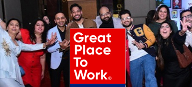 Group of employees in the India office posing for a picture, holding a banner that says, "Great Place To Work"