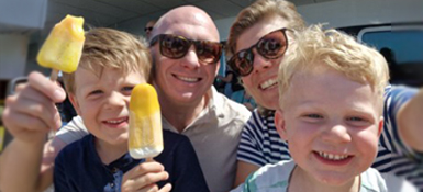 Marije with her family on a boat, taking a selfie with popsicles.
