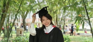 An employee in her graduate ceremony dress