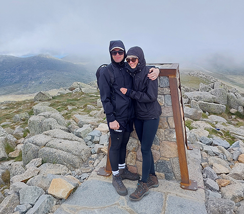 Adrian Cawley, Site Care Partner - FSP (Senior Clinical Research Associate), on top of a mountain with his partner