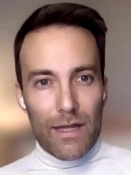 Woman looking at her cellphone while seating in front of a window