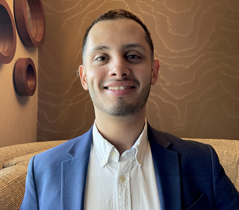 Daniel, a male Argentinian and Associate Project Director at Parexel, smiling at the camera, wearing a shirt and jacket.