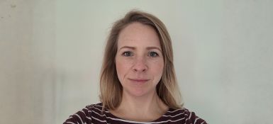 Kate smiling, blonde hair, with a black and white striped shirt