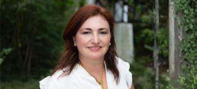 Maria smiling and wearing a white shirt