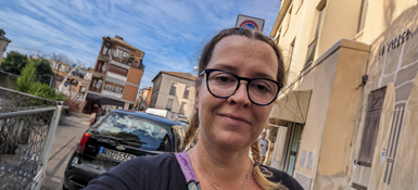 Juliane, female white German, with glasses and two braided plaits, walking in the streets of Berlin.