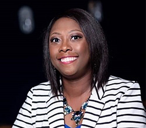 Marlayna, a Black-American women, wearing shoulder long hair, a black-white striped jacket and a necklace.