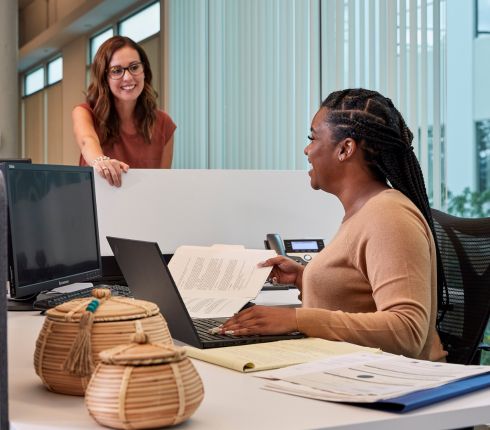Two females talking over a desk
