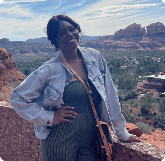 Female employee posing for a photo with beautiful landscape in the background