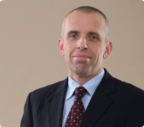 Artur, a male white Polish, short hair, wears a jacket, shirt and tie.