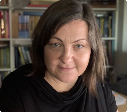 Marzena, a female white Polish, with dark blond long hair and black shirt, smiling.