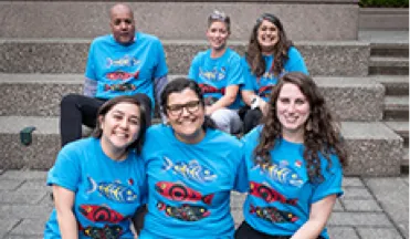 A Group of PHSA employees posing with matching shirts with indigenous artwork