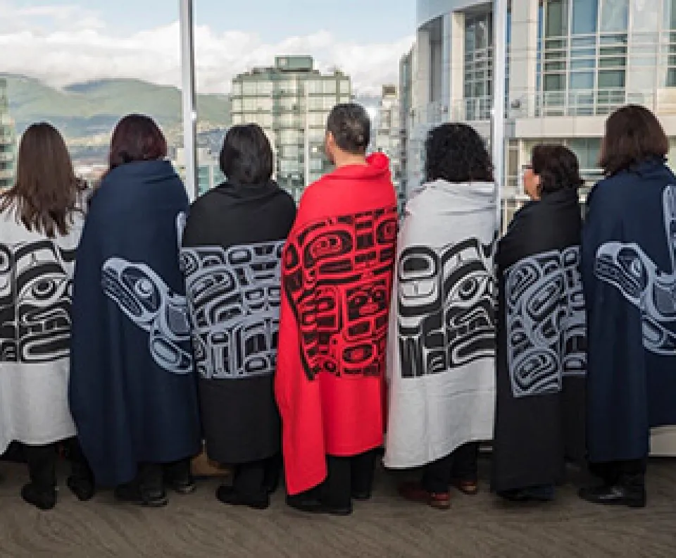 Indigenous PHSA employees displaying blankets with traditional indigenous patterns