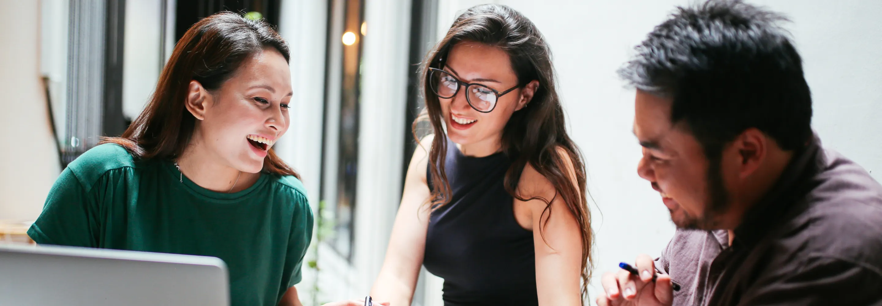 two employees in office attire looking at a tablet