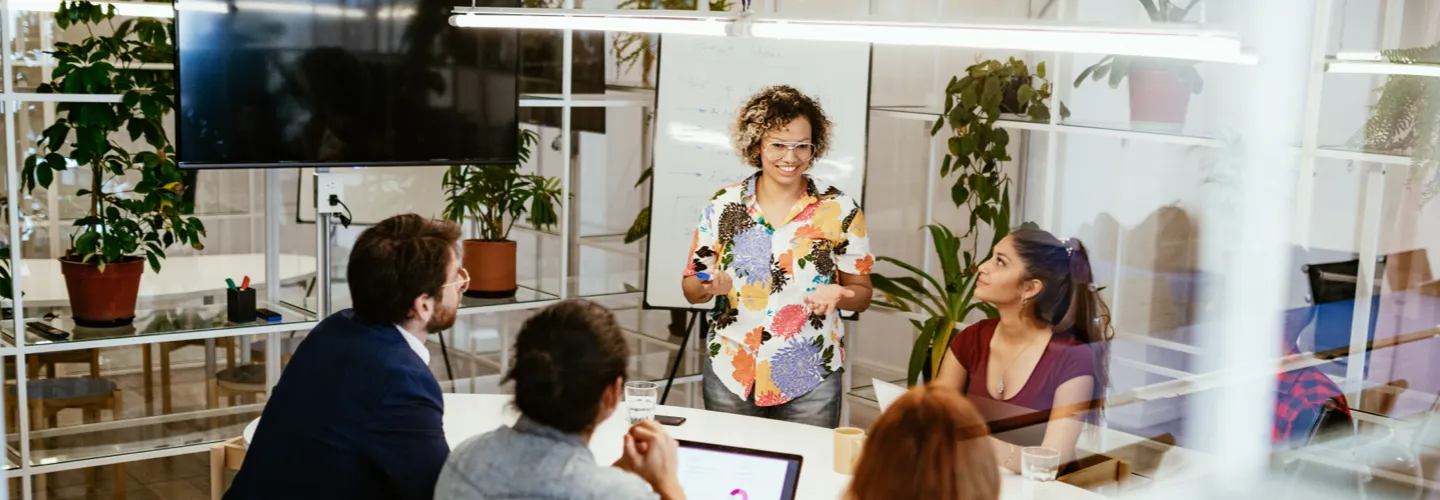 three young employees looking at a tablet and smiling