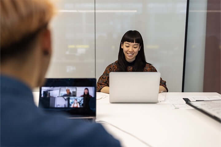 female employee speaking to candidates through a video conferencing app on her laptop