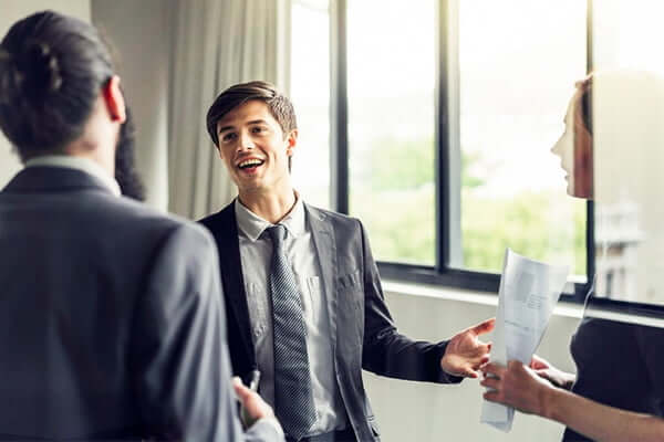 three colleagues having a conversation in an office